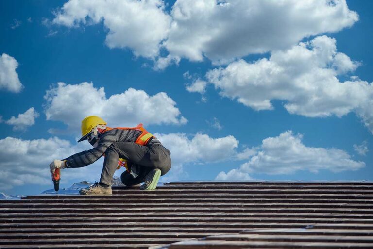 Attic roof decking with condensation, damp insulation, and visible moisture staining on wooden rafters