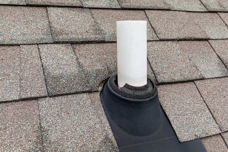 Attic view showing dark water stains and softened roof decking beneath shingles.